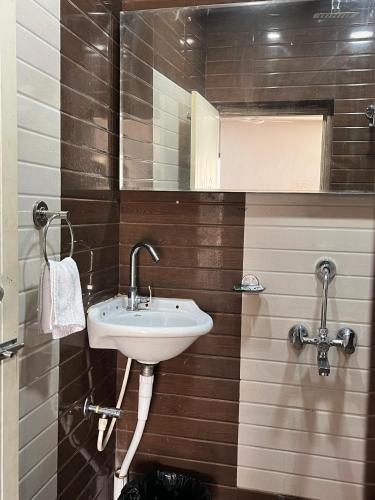 a bathroom with a sink and a mirror at Amantran Hotel & Resort, Chilapata in Patkapāra