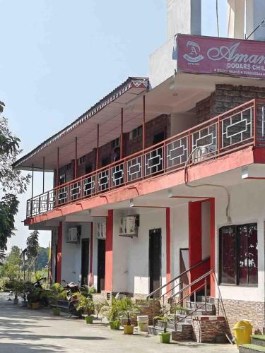 a building with a balcony on the side of it at Amantran Hotel & Resort, Chilapata in Patkapāra