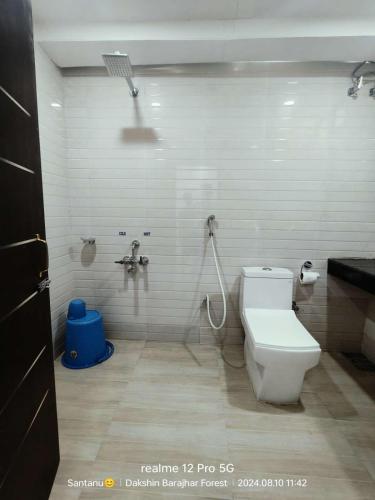 a bathroom with a shower and a toilet in it at Amantran Hotel & Resort, Chilapata in Patkapāra
