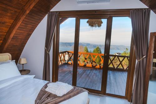 a bedroom with a bed and a balcony with a view at Exclusive Hill Sapanca in Sapanca