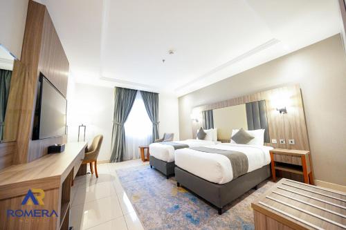 a hotel room with a bed and a desk at Romera Hotel in Jeddah