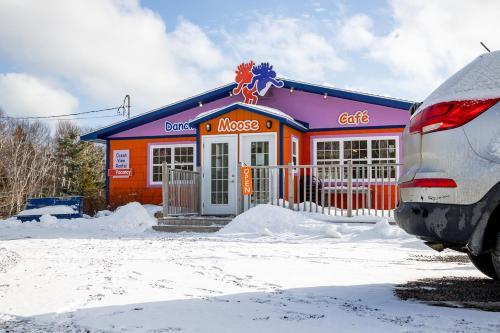a car parked in front of a building in the snow at The Birch Plain Tower in Englishtown