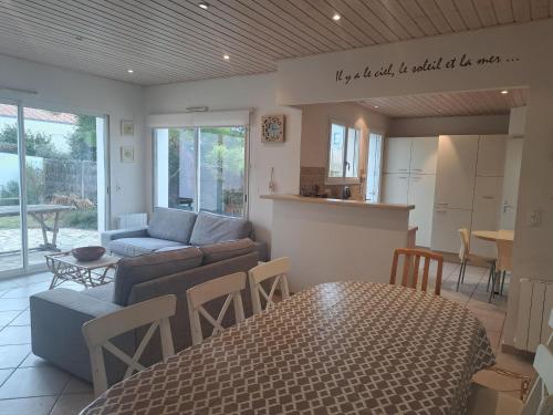 un salon avec un canapé et une table dans l'établissement Maison bord de mer pour 9 pers. avec terrasse, BBQ, WiFi - à 300m de la plage, tout confort - FR-1-323-501, à Saint-Hilaire-de-Riez