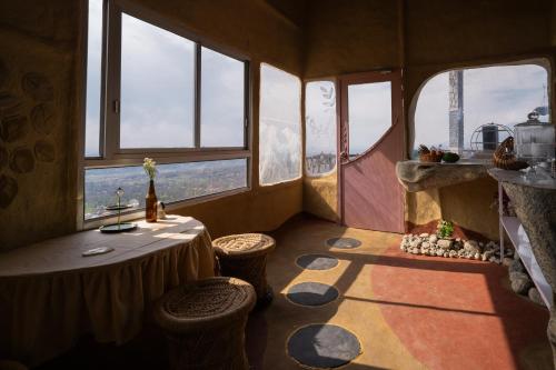 a small room with a table and some windows at Paarli Dhara capsules in Bīr