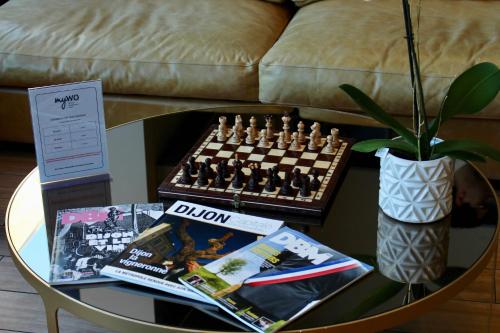 a table with a chess board and magazines on it at BEST WESTERN HOTEL DIJON QUETIGNY in Quétigny