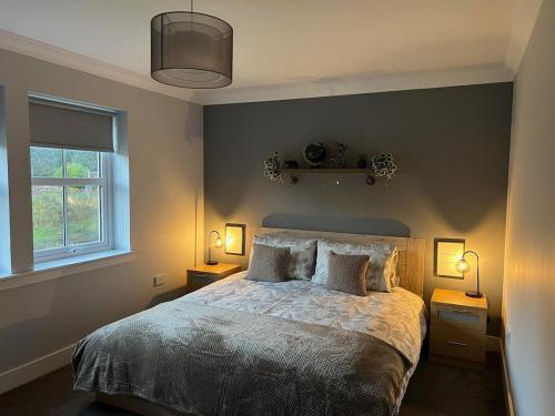 a bedroom with a large bed with two night stands at Gellyburn Cottage in Kinross