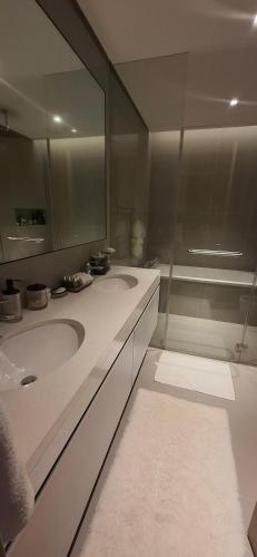 a bathroom with two sinks and a glass shower at almoaj ,juman 2 marina view,level3 in Muscat