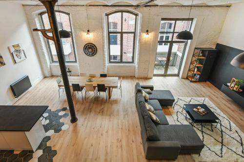 un salon avec un canapé et une table dans l'établissement Loft Dugay - Welkeys, à Tourcoing