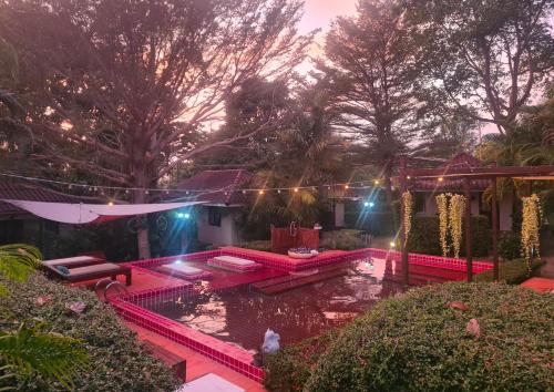a house with a pond with pink lights in the yard at Red Moon Hideaway in Ko Chang