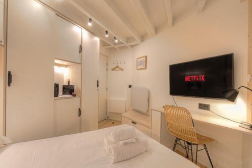 a bedroom with a bed and a desk with a tv at Suite Premium proche Tête d'Or in Lyon