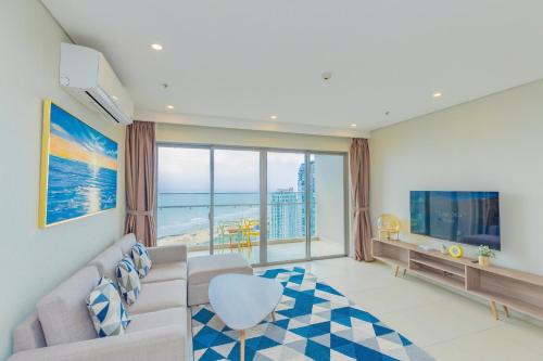 a living room with a couch and a large window at The Sóng Vũng Tàu Hideaway in Vung Tau