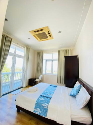 a bedroom with a large bed and a balcony at Sea Home - Villa Sealinks Mui Ne 3br O867,7O7,123 in Ấp Phú Tịnh (2)