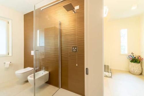a bathroom with a shower with a toilet and a sink at Villa Incanto in Mezzegra