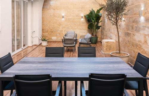 a dining room with a blue table and chairs at Valletta Waterfront Backyard Flat by ArcoBnb in Il-Furjana