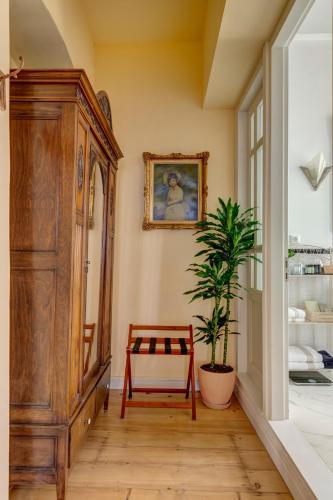 a room with a wooden cabinet and a potted plant at Palazzo Santa Maria - Historic Hotels of Europe in Ermoupoli