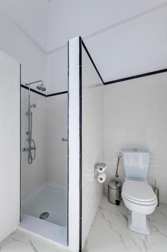 a white bathroom with a toilet and a shower at Palazzo Santa Maria - Historic Hotels of Europe in Ermoupoli
