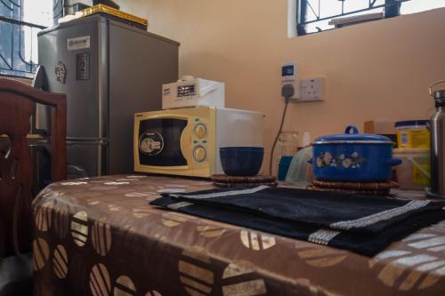 a table with a microwave sitting on top of it at New Star House in Arusha