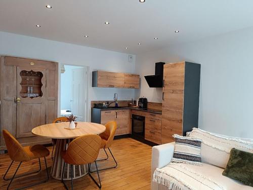 un salon avec une table et une cuisine dans l'établissement Appartement Perros-Guirec en plus, à Perros-Guirec