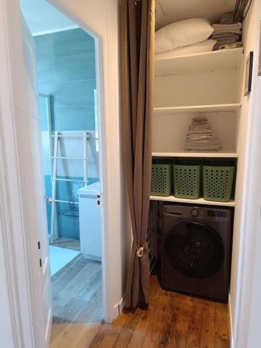 - une buanderie avec un lave-linge dans un placard dans l'établissement Appartement Perros-Guirec en plus, à Perros-Guirec