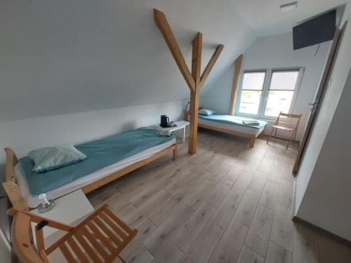 a bedroom with a bed and a table and chairs at Pokoje Bema 14 in Ciechocinek