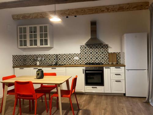 une cuisine avec une table, des chaises et un réfrigérateur dans l'établissement MaisonAdèle, à Caromb