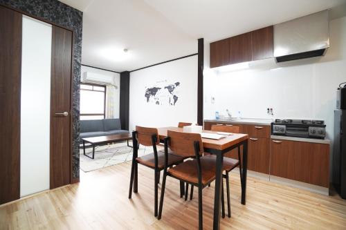 a kitchen and dining room with a table and chairs at Charade Kyobashi in Osaka