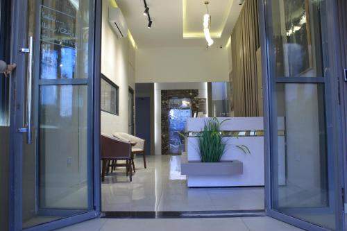 a hallway with doors and a plant in a pot at Azmal Hotel & Suites in Irbid