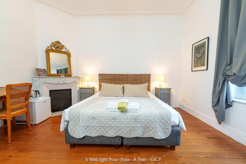 a bedroom with a bed and a table and a mirror at Un Nid en Camargue in Salin-de-Giraud