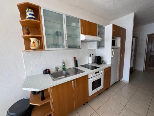 une petite cuisine avec un évier et une cuisinière dans l'établissement appartement 2-4 pers, vue mer !, à Casaglione