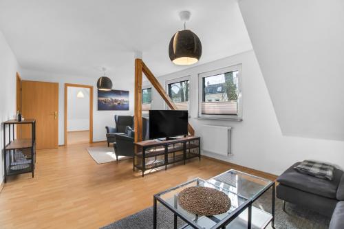 a living room with a couch and a tv at 24-7 Living - Unna Central City Apartments in Unna