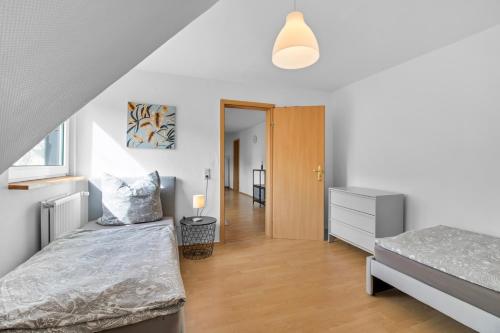 a bedroom with two beds and a hallway at 24-7 Living - Unna Central City Apartments in Unna