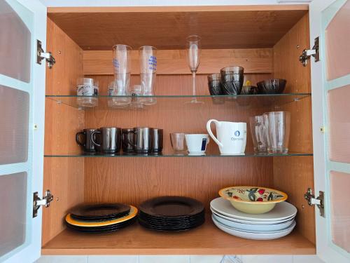 a cupboard with plates and dishes in it at Hero Avenue Apartment in Narva