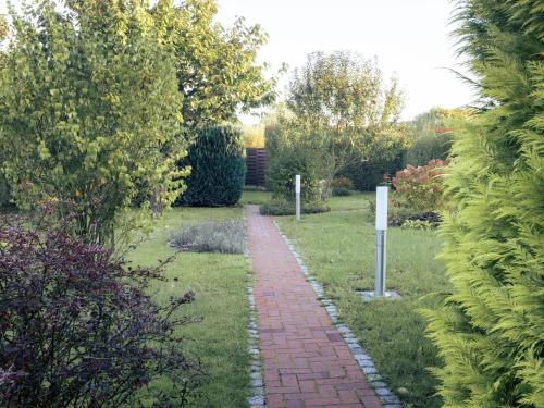 a brick path in a garden with trees and bushes at Eichholz-Hof kleines Ferienhaus Objekt-ID 15465-8 in Waren