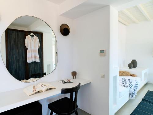 a white room with a mirror and a table and chair at Mykonos Rocks Villas & Suites in Mýkonos City