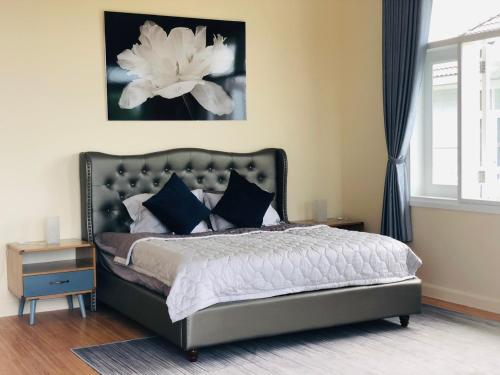 a bedroom with a bed with a large white flower on the wall at Sea Home - Villa Sealinks Mui Ne 3br O867,7O7,123 in Ấp Phú Tịnh (2)