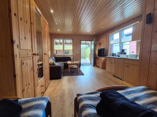 a living room with wood paneling and a couch and a kitchen at Eichholz-Hof kleines Ferienhaus Objekt-ID 15465-8 in Waren
