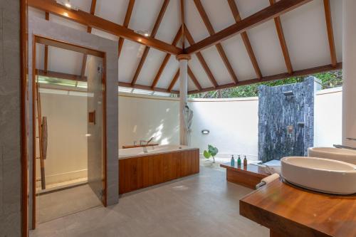 un baño con bañera y lavabo en Dhigufaru Island Resort, en Atolón Baa