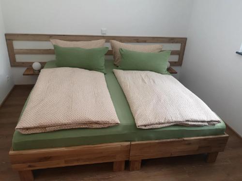 a wooden bed with two pillows on top of it at Franzl Hof Zorell in Ravensburg