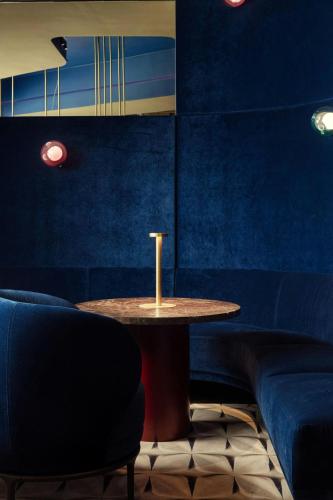 a table and chairs in a room with blue walls at Courtyard by Marriott Brno in Brno