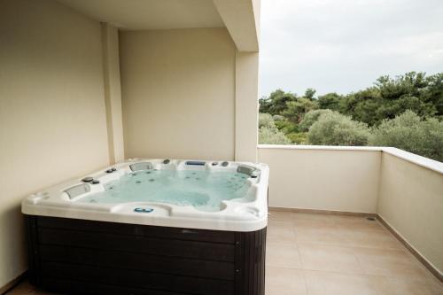 a bath tub in a room with a window at Magnolia Villas Thassos in Potos