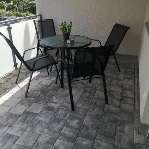 a table and chairs on a balcony with a potted plant at Franzl Hof Zorell in Ravensburg
