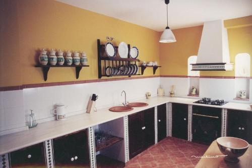 eine Küche mit einer Theke mit 2 Waschbecken und Spiegeln in der Unterkunft La Posada Real in Priego de Córdoba