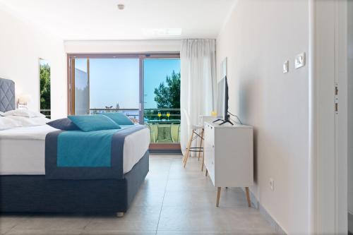 a bedroom with a bed and a tv and a window at The Residence Aparthotel in Podstrana