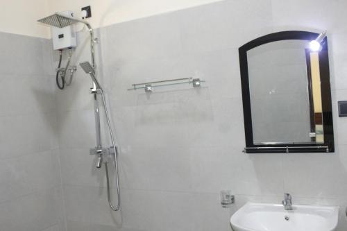 a bathroom with a shower and a sink and a mirror at Cinnamon Edge in Mihiripenne