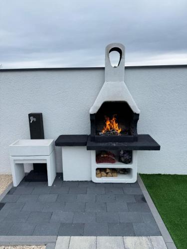 a fireplace sitting next to a wall with a bench at Luxury Villa Blue Sky in Široki Brijeg