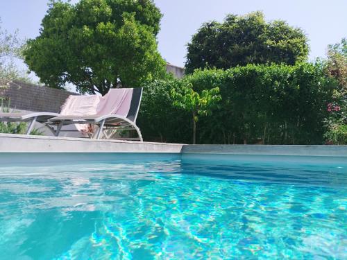deux chaises assises à côté d'une piscine dans l'établissement Parenthèse à Nîmes, à Nîmes
