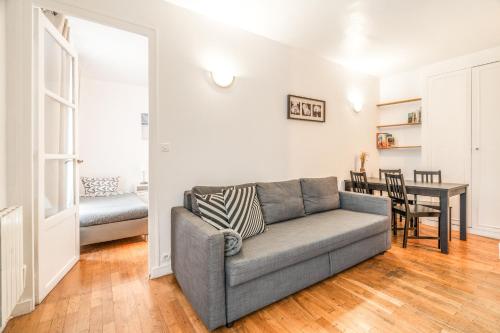 un salon avec un canapé et une table dans l'établissement Levis Charming Place, à Paris