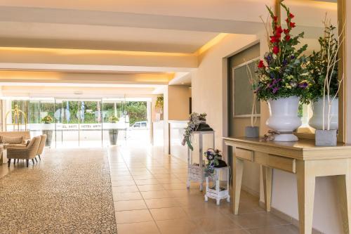 a lobby with a table with a vase of flowers on it at Ariti Grand Hotel in Corfu Town
