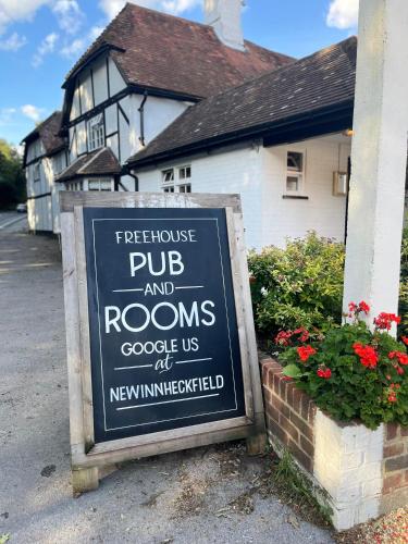 a sign in front of a house with a house at The New Inn Heckfield in Hook