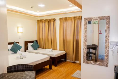 a hotel room with two beds and a mirror at Anahaw Seaside Inn in Bantayan Island